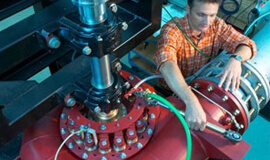 Ein Bild zeigt den Turbinenversuchsstand, auf dem eine Francisturbine untersucht wird. Ein statisches Stroboskop RT STROBE 5000 XENON wird verwendet, um verschiedene Betriebskurven abzufahren und Messwerte aufzuzeichnen. Dies ermöglicht die Berechnung der Eigenschaften der Turbine.